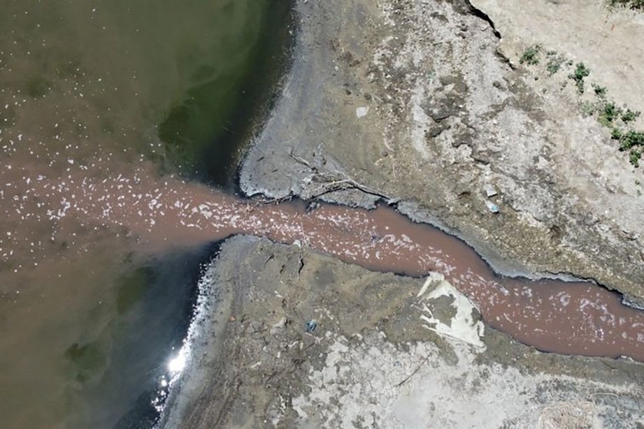 Vista aérea de un curso de agua con una descarga de efluentes hacia el Río Salado en una investigación por contaminación ambiental.