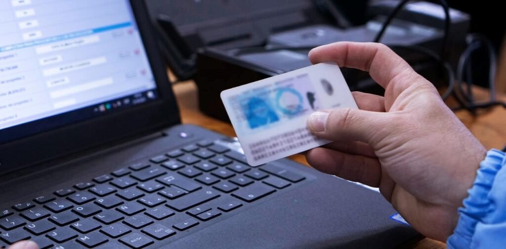 Documento de identidad frente a una computadora.